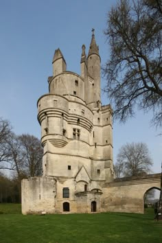 an old castle like building sitting on top of a lush green field