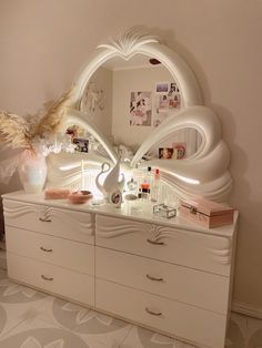 a white dresser topped with a mirror and lots of drawers