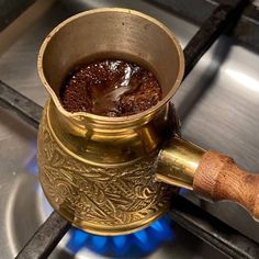 a metal pot filled with liquid sitting on top of a stove