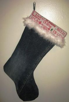 a christmas stocking hanging on the wall with an old pair of jeans in it