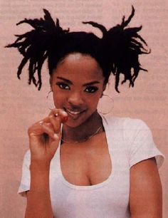 a woman with dreadlocks on her head brushing her teeth