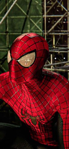 a close up of a spider - man mask on display in front of some scaffolding