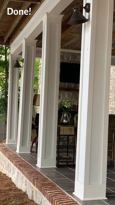 the front porch is covered with white pillars and columns that are lined up against each other