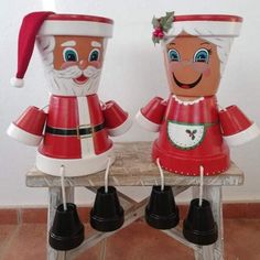 two red and white christmas decorations sitting on top of a wooden bench next to each other