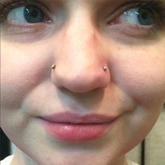 a woman with piercings on her nose looking at the camera