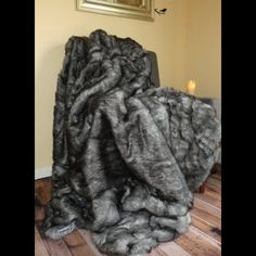 a large pile of fur sitting on top of a wooden floor next to a painting