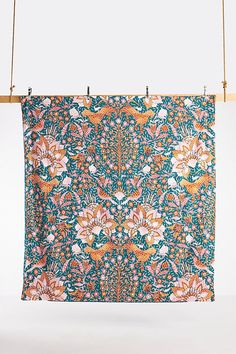 an orange and blue floral print hanging on a clothes line