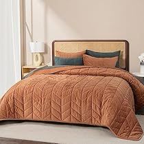 the bed is made up with an orange comforter and matching pillow cases, along with two nightstands