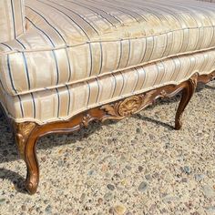 an antique style bench with blue and white striped upholster