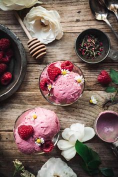 raspberry mousse with fresh flowers and honey on the side, surrounded by other desserts