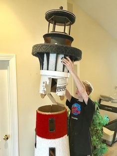 a boy is playing with a toy lighthouse