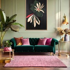 a living room with green walls, pink and gold furniture and paintings on the wall