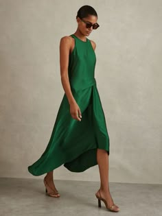 a woman in a green dress and sunglasses