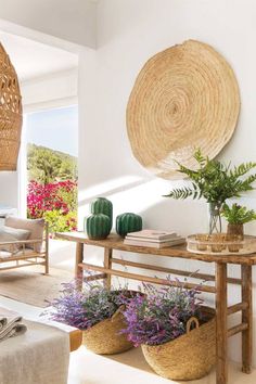 a living room filled with lots of furniture and plants on top of a wooden table