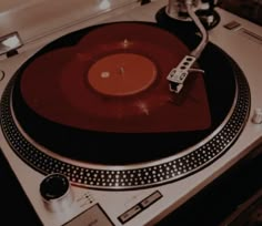 a turntable with a red record on it's side and a microphone attached to the top