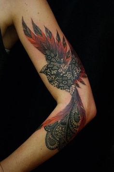 a woman's arm with an intricate tattoo design on her left arm and shoulder