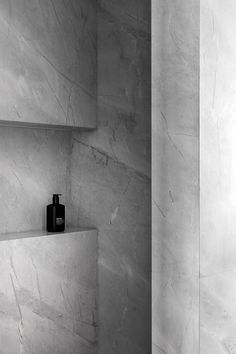 a bathroom with white marble walls and shelves