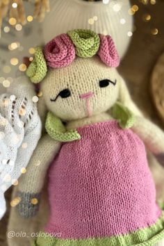 a knitted stuffed animal wearing a pink dress