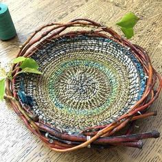 a basket that is sitting on the floor next to some scissors and thread spools