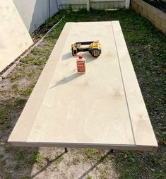 a table that is being constructed with plywood and tools on it in the yard