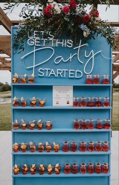 a blue sign that says get this party started with honey jars and flowers on it