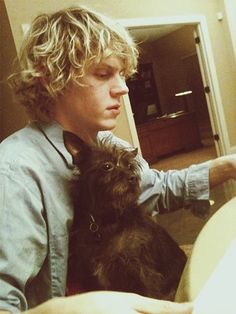 a young man holding a dog in his lap