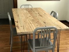 a wooden table with metal chairs in a room