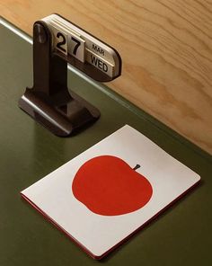 an apple shaped magnet sitting on top of a desk