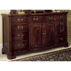 a large wooden dresser sitting in a living room next to a rug on the floor