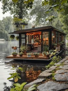 a small houseboat floating on top of a lake surrounded by trees and greenery