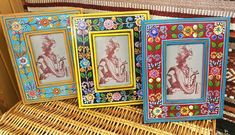 three framed pictures sitting on top of a wicker chair