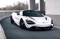 a white and black sports car parked on the side of a road next to a building