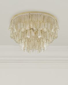 a chandelier hanging from the ceiling in a room with white walls and trimmings