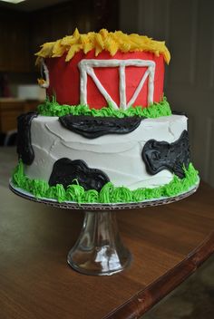 a cake decorated with farm animals and a red barn on top of a wooden table