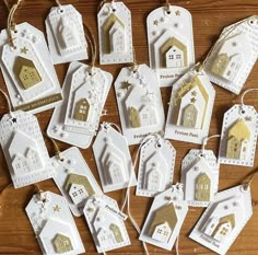 white and gold christmas ornament hanging from string on wooden table with other ornaments