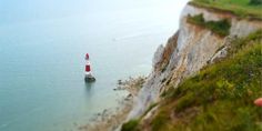 a red and white lighthouse sitting on top of a cliff