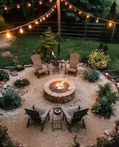 an outdoor fire pit surrounded by chairs and lights