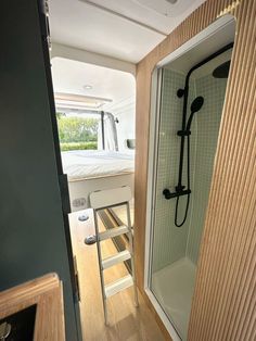 the inside of a camper with a shower and bed in the back ground area