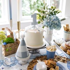 a white cake sitting on top of a table covered in blue and white plates filled with food