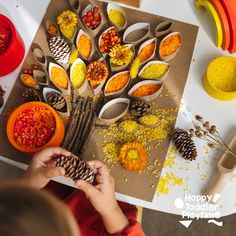 a child is making an autumn tree out of pine cones