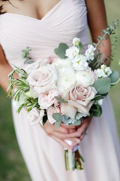 a bride holding a bouquet of flowers in her hands