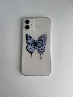 a white phone case with a butterfly and flowers on the back, sitting on a table