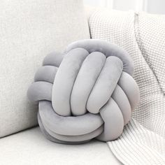 the pillow is shaped like a knot on the back of a couch with it's cushion