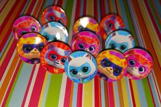 a bunch of littlest petties sitting on top of a colorful striped table cloth