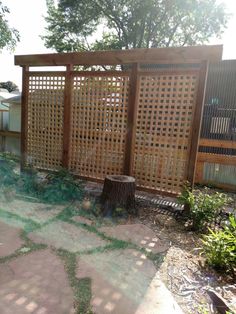 an outdoor area with a wooden fence and tree stump