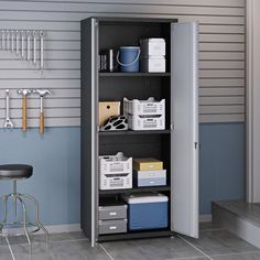 a metal storage cabinet filled with boxes and files next to a stool in a room