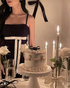 a woman standing next to a table with a cake on it