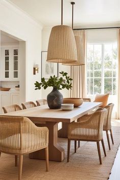 a dining room table with chairs and a vase on it