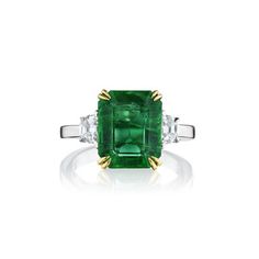 This 3 stone, 4.99ct natural green emerald ring. Flanked by Cadillac-cut diamonds weighing 0.49 carats. Has 18KT yellow gold prongs and diamonds are set in 18kt white gold and a polished 18kt white gold band. The ring total weight is 5.48 carats. Luxury Three Stone Diamond Emerald Ring, Luxury Three Stone Asscher Cut Emerald Ring, Luxury Asscher Cut Three Stone Emerald Ring, Green Emerald Ring With Three Stone Baguette Cut, Green Baguette Cut Three Stone Emerald Ring, Green Emerald Three Stone Diamond Ring, Luxury Green Three Stone Diamond Ring, Luxury Green Diamond Three Stone Ring, Luxury Three-stone Green Diamond Ring