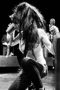 a woman with long hair holding a microphone